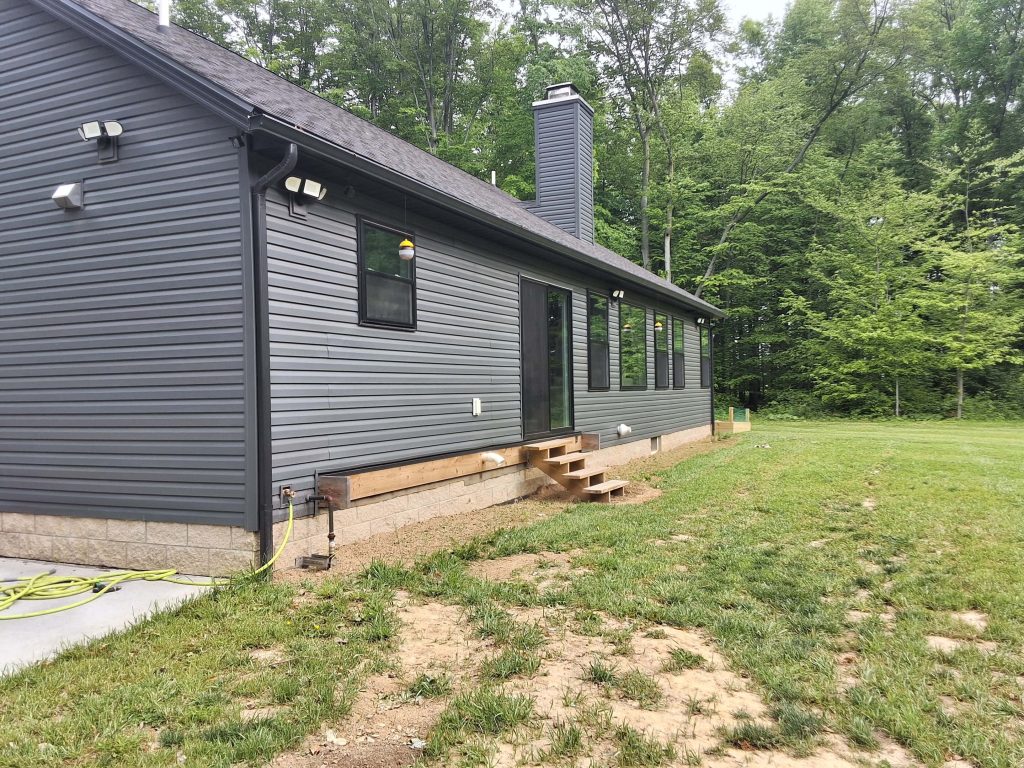 D Miller Exteriors Apple Creek OH installs charcoal gray vinyl siding on single-story ranch home side elevation