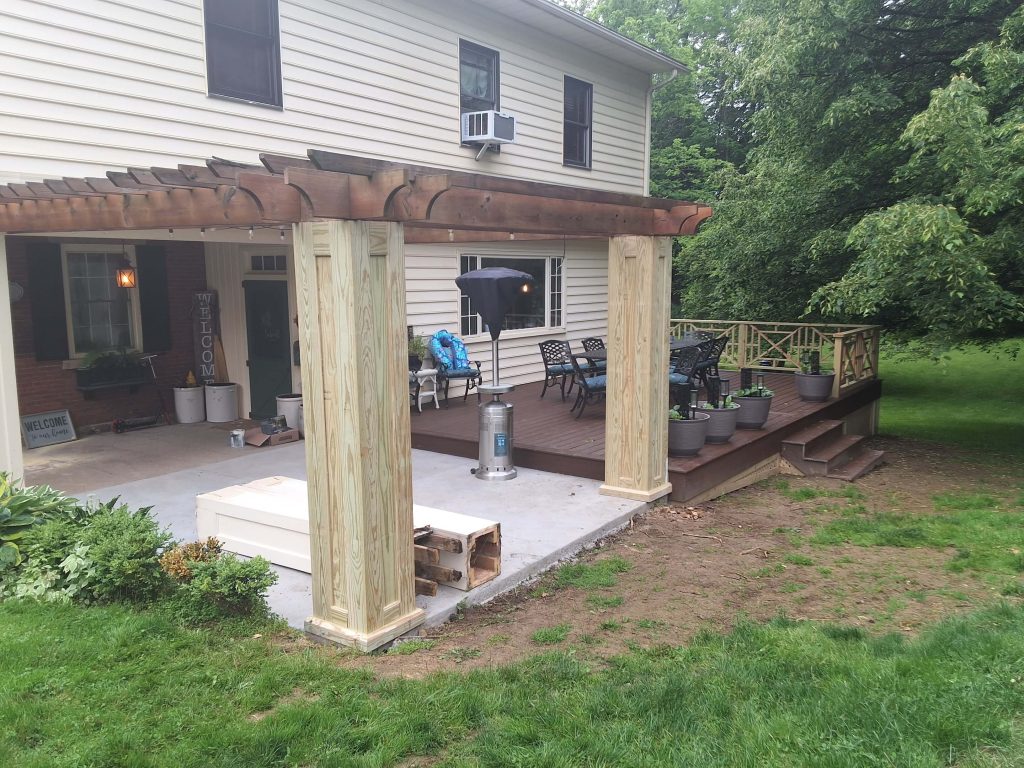 D Miller Exteriors Apple Creek OH pergola posts anchored beside freshly finished backyard deck and patio