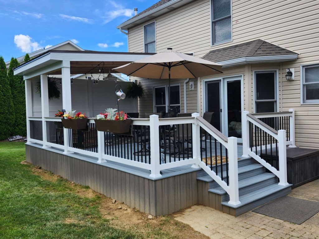 D Miller Exteriors Apple Creek OH upgrades backyard with gray composite deck, white-trim rails, black balusters, metal roof cover, and planter boxes