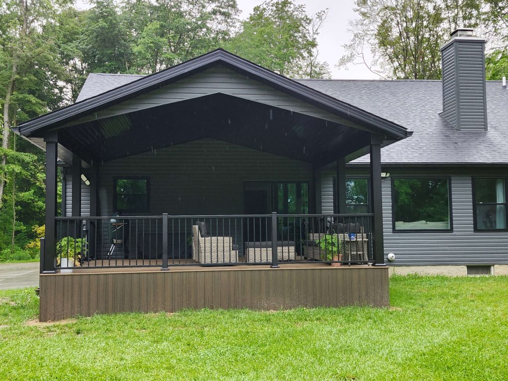 Front elevation of gable roof porch on gray home, custom rail and composite floor by D Miller Exteriors Apple Creek OH