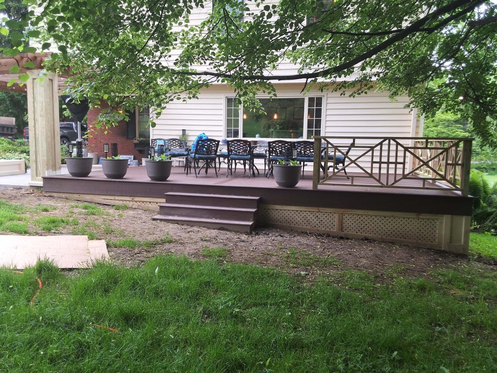 Front view of composite deck with three-step stairs and dining set by D Miller Exteriors Apple Creek OH