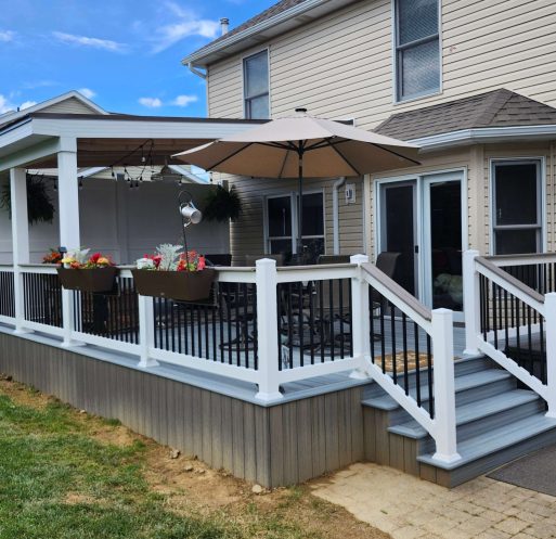 D Miller Exteriors Apple Creek OH upgrades backyard with gray composite deck, white-trim rails, black balusters, metal roof cover, and planter boxes