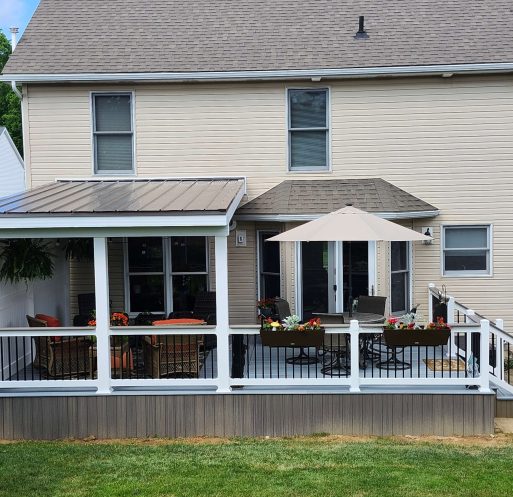 Finished composite deck and screened roof addition with white rails and flower planters built by D Miller Exteriors Apple Creek OH